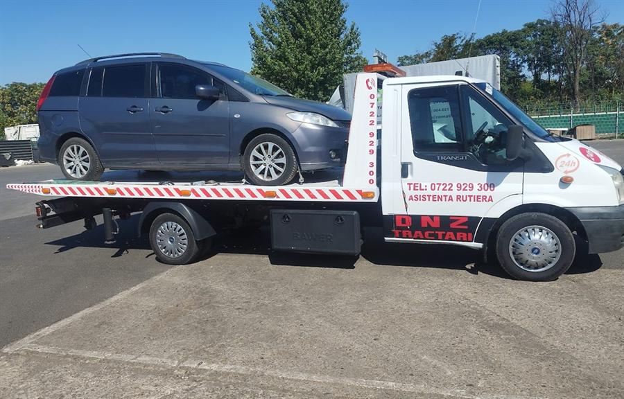 Monovolum gri transportat pe platformă.
