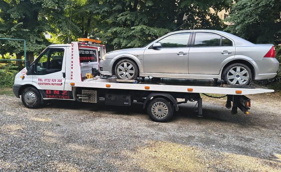 Berlină argintie transportată pe platformă.