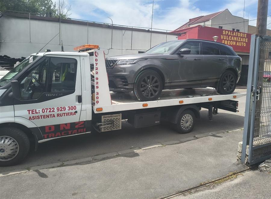 SUV premium gri, transportat pe platformă.